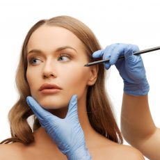 21277042 - cosmetic surgery concept - woman face and beautician hands with pencil